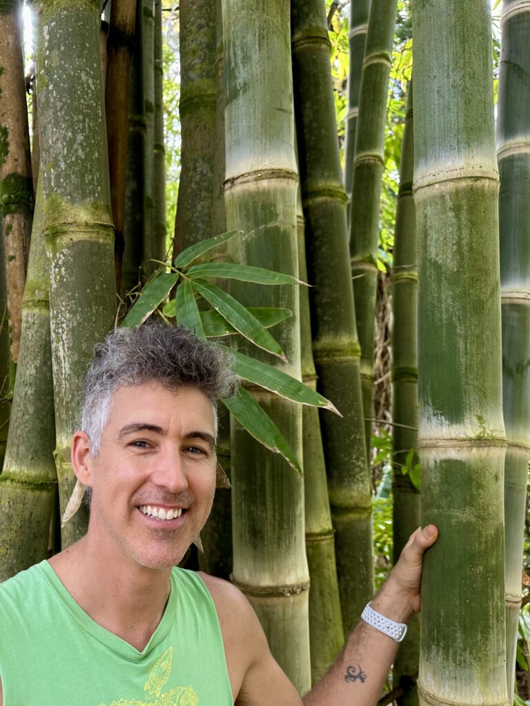 Seth with his hand on a bamboo stalk that is easily five inches thick